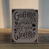 silver and black card that says gobble gobble til you wobble