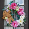 flora wreath with a bow hanging on a brown door
